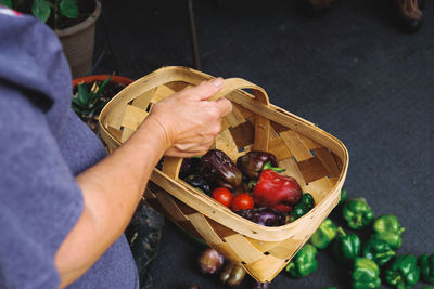 Midsection of person carrying vegetable basket