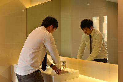 Businessman washing hands in bathroom