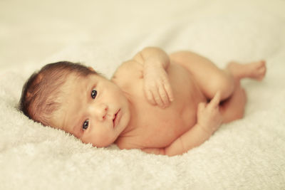 Portrait of cute baby lying on bed