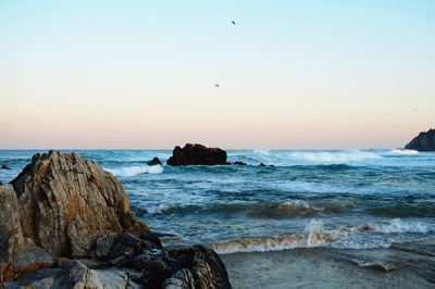 Scenic view of sea against clear sky at sunset