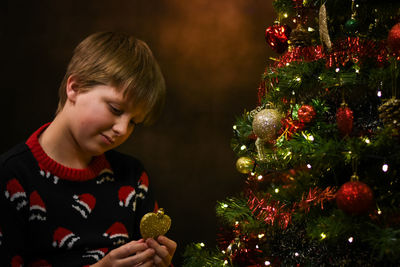 Side view of boy decorating christmas tree