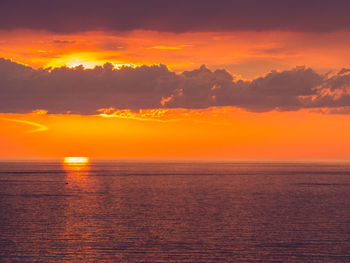 Scenic view of sea against romantic sky at sunset