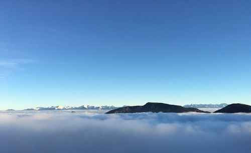 Scenic view of mountains against blue sky