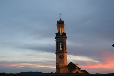 Low angle view of clock tower against cloudy sky