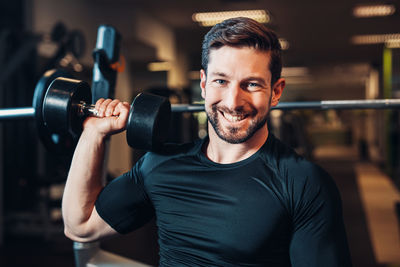 Portrait of young man exercising in gym