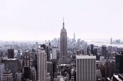 Empire state building in city against clear sky