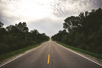 Road amidst trees against sky