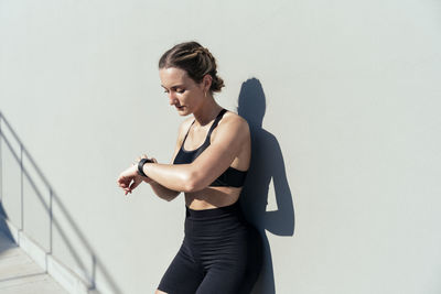 Young woman monitoring heart rate through smart watch