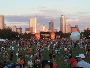 Crowd in city against sky