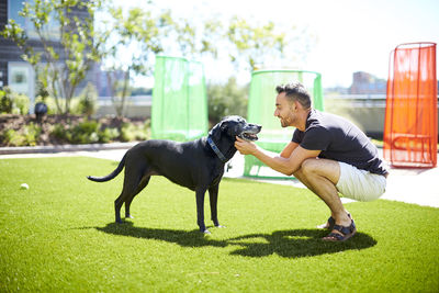 Side view of woman with dog against plants