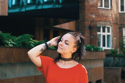 Beautiful young woman looking away in city