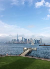 City at waterfront against cloudy sky