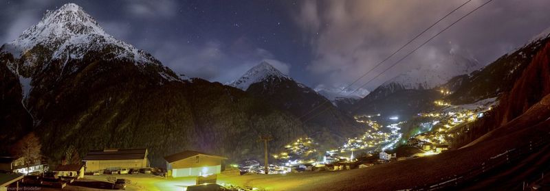 Panoramic view of illuminated mountains against sky at night