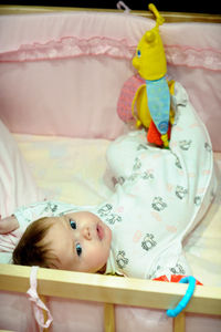 High angle view of cute baby sleeping on bed at home