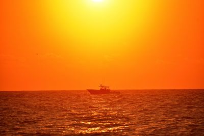 Scenic view of sea against orange sky