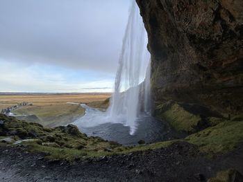 Scenic view of waterfall against sky