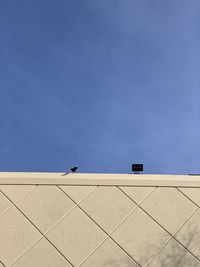 Low angle view of lamps on building against sky