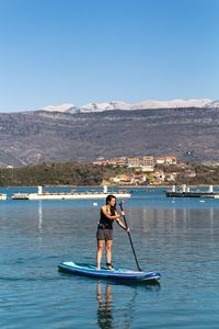 Young woman paddleboarding on sea