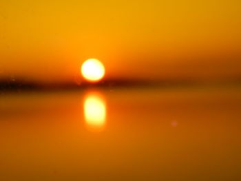 Defocused image of sea against romantic sky at sunset