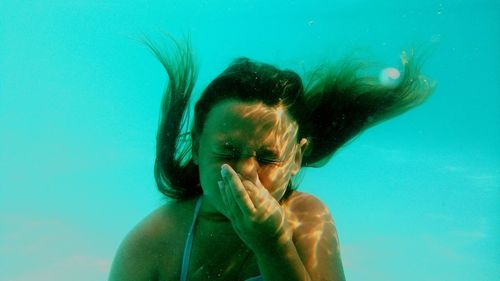 Close-up of girl holding nose underwater