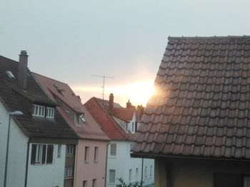 Buildings in town against sky during sunset