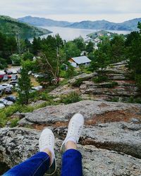 Low section of woman standing by tree against sky