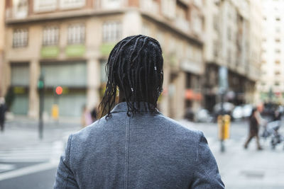 Rear view of young man standing in city 