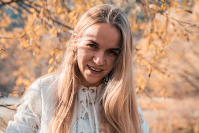 Portrait of a smiling young woman during autumn