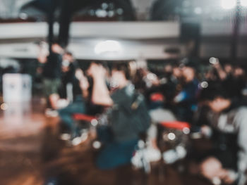 Defocused image of people sitting in city