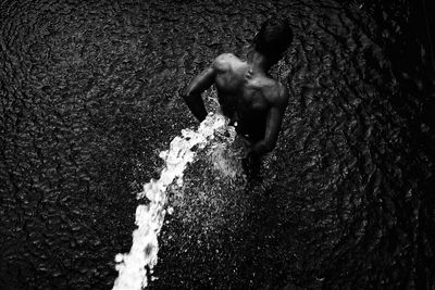 High angle view of shirtless man in sea