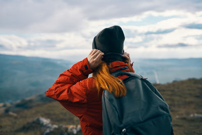 Rear view of man looking at mountain against sky