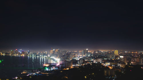 Illuminated cityscape against sky at night