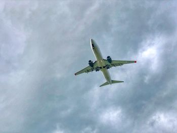 Low angle view of airplane flying against sky