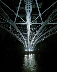 Underneath view of illuminated bridge over river