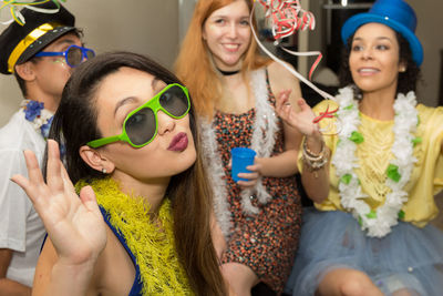 Portrait of young woman puckering against smiling friends during party