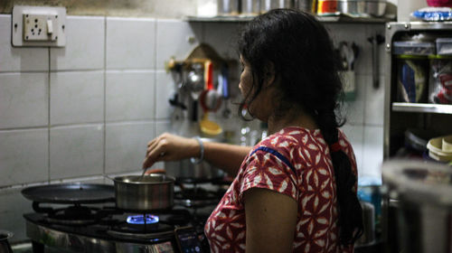 Woman preparing food while standing in kitchen at home