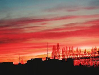 Silhouette buildings against sky during sunset