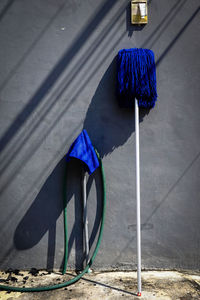Blue umbrella hanging on street against wall