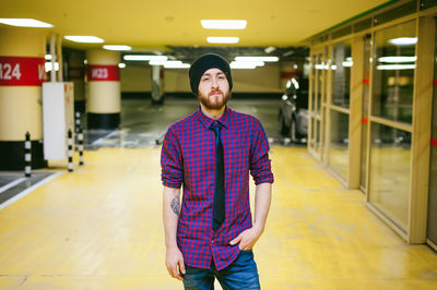 Portrait of young man standing in illuminated basement