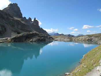 Panoramic view of lake and mountains against blue sky