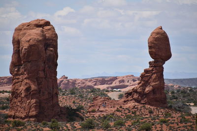 Rock formations on landscape against cloudy sky