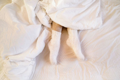 Legs in warm leggings and wool socks peek out from under the blanket.