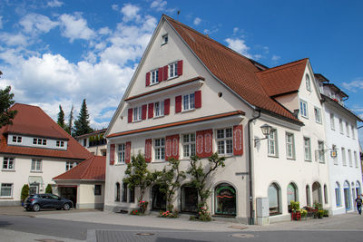 Residential building by road against sky