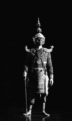 Statue against black background