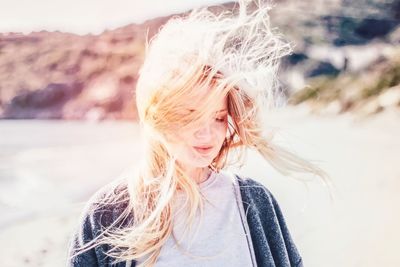 Young woman with tousled hair at beach