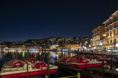 Boats moored at harbor at night