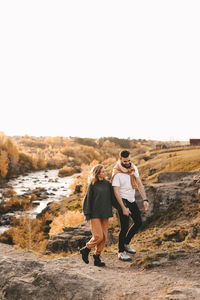 A happy couple in love a man and a woman are traveling walking hiking in the autumn forest in nature