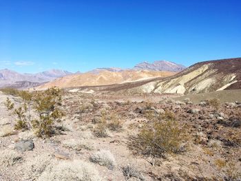 Scenic view of arid landscape against clear blue sky