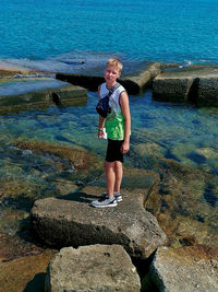 Woman standing on rock at sea shore