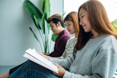 Group of young people sitting and enjoyed reading books together